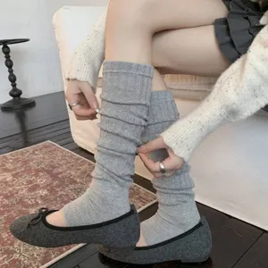 Detailed view of grey knit slouchy leg warmers featuring a vertical stripe texture