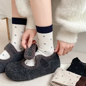 Close-up detail of Korean style floral mid-calf socks paired with cozy fluffy shoes.