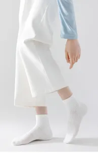 Close up detail view of white mesh breathable short socks worn by model in clean studio shot.