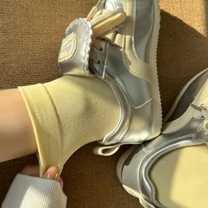 Gros plan de chaussettes en coton côtelé jaune et de baskets argentées métallisées