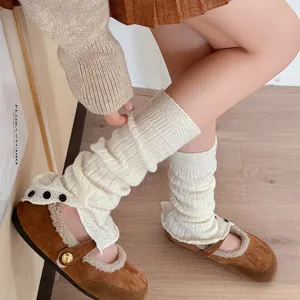 Detail view of knitted leg warmers with side buttons and cute stacked design for winter.