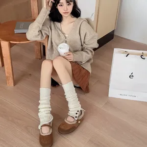 Detailed view of stylish knitted leg warmers with button closure for autumn and winter outfits.