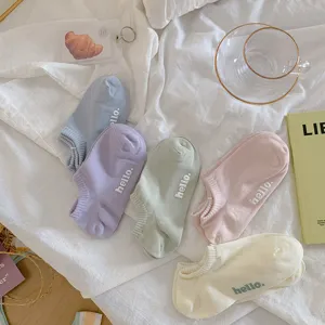 Detailweergave van vijf paar kleurrijke pastel katoenen sokken met de tekst hello
