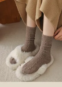Close-up detail of women's cable knit wool socks texture, cozy retro autumn style.
