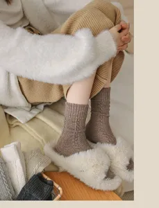Close-up shot of cozy cable knit wool socks in brown, paired with fluffy slippers, lifestyle detail.
