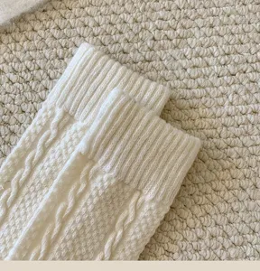 Cozy wool-blend cable knit sock detail featuring soft ribbed cuff and classic winter texture.
