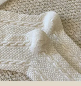 Close-up detail view of women winter warm cable knit wool socks in solid white fabric.