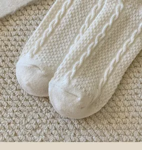 Close-up of women's cable knit wool socks, showing soft texture and cozy winter design details.