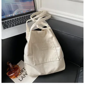 Makro-Detailansicht der cremefarbenen Cord-Tasche mit Fokus auf die weiche Rippstruktur