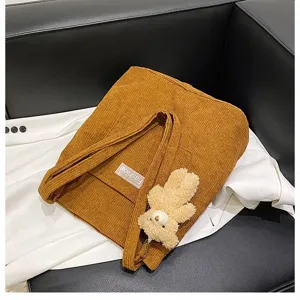 Detailansicht einer braunen Cord-Einkaufstasche mit süßem Teddybär-Anhänger-Accessoire