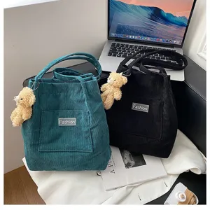 Stilvolle Kord-Eimertaschen in Blaugrün und Schwarz mit süßen Teddybär-Anhängern in Szene
