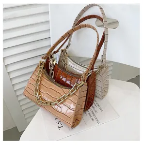 Set de tres bolsos bajo el brazo con estampado de cocodrilo en varios tonos tierra.