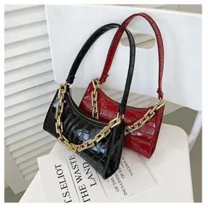 Detalle de bolsos de hombro brillantes con relieve de cocodrilo y cadenas doradas.