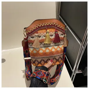 Gewebte Beuteltasche im Ethno-Stil mit bunten Quasten und gemustertem breitem Riemen