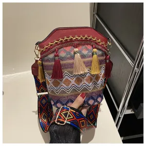 Detailansicht einer böhmischen Ethno-Beuteltasche mit bunten Quasten und geometrischem Gurt