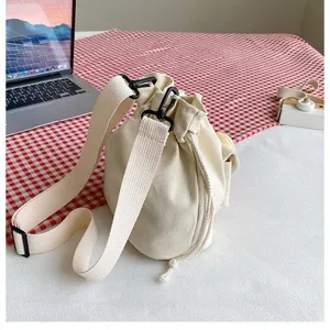 Detail der beigen Canvas-Beuteltasche mit verstellbarem Schultergurt und Kordelzug