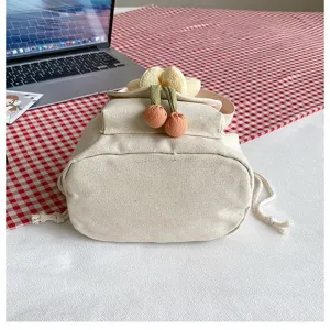 Detailansicht der niedlichen Canvas-Umhängetasche mit dekorativen floralen Kirsch-Anhängern.