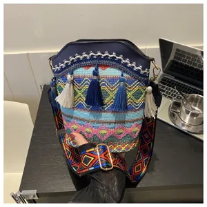 Ethnische gewebte Beuteltasche mit bunten Quasten und geometrischem Schultergurt.