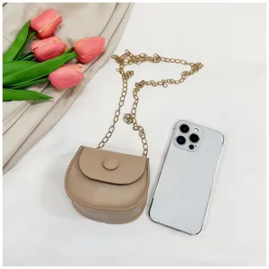 Μίνι μπεζ τσάντα χιαστί με αλυσίδα δίπλα σε smartphone για πλήρη σύγκριση μεγέθους