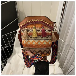 Nahaufnahme einer Bucket Bag im Ethno-Stil mit bunten Quasten und Riemen.
