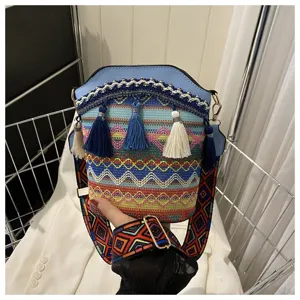 Nahaufnahme einer Bohème-Beuteltasche mit bunten Webmustern und blauen Quasten-Anhängern