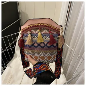 Detaillierte Ansicht der ethnischen Eimertasche mit bunten Quasten und geometrischem Riemen