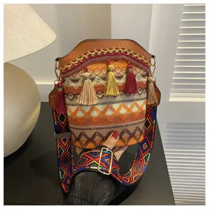 Detail einer Boho-Beuteltasche mit bunten Quasten und ethnischen Webmustern