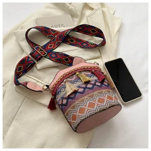 Boho-Eimer-Tasche im ethnischen Stil mit bunten Quasten und breitem Gurt auf Blazer