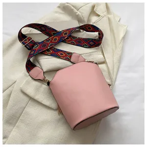 Detailansicht einer schicken rosa Beuteltasche mit buntem Schultergurt im Ethno-Stil