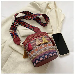 Nahaufnahme der Bohème-Eimertasche mit bunten Quasten und breitem Riemen