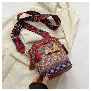 Nahaufnahme einer ethnischen Eimertasche mit bunten Webmustern und feinen Quasten