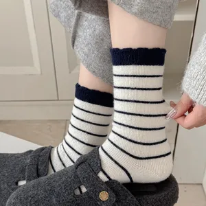 Detailansicht von weiß-schwarz gestreiften Wollsocken, welche Elastizität zeigen