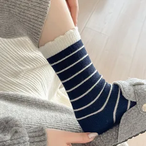 Nahaufnahme von dunkelblau weiß gestreiften Wintersocken mit grauem Filzpantoffel