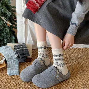 Cozy winter women mid-tube wool socks with classic fair isle snowflake pattern detail.