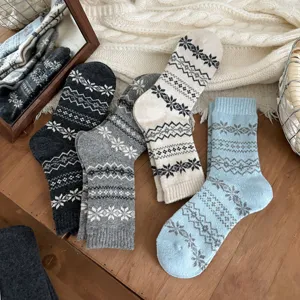 Cozy wool-blend crew socks featuring classic Fair Isle snowflake patterns for winter warmth.