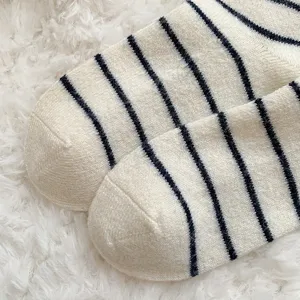 Nahaufnahme von dicken gestreiften Socken mit weicher Textur auf weißem Webpelz
