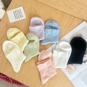 Vue détaillée de diverses chaussettes en coton pastel sur une surface en bois