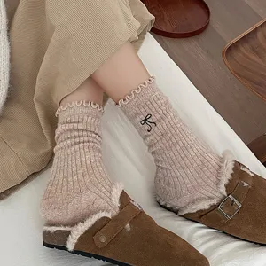 Vue détaillée de chaussettes d'hiver en laine pour femmes avec broderie nœud et bord dentelle.