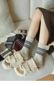 Cozy knit wool blend socks featuring classic stripes, styled with furry slip-on slippers.