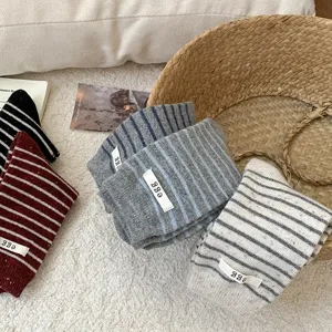Detailed view of striped wool socks with decorative 'egg' tags in various colors