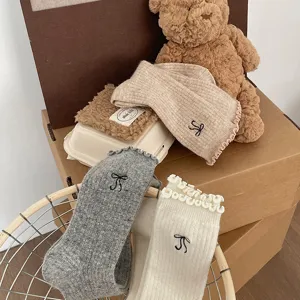 Gros plan détaillé de chaussettes d'hiver douillettes avec broderie de nœud et bordure.