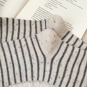 Macro view showing the warm knit texture of striped wool socks with colorful flecks
