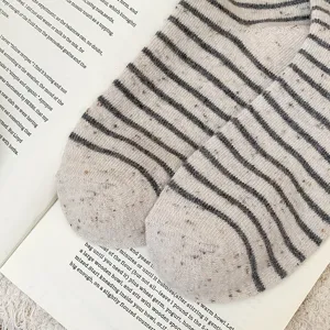 Close-up detail of warm striped wool-blend socks showing the cozy marled texture.