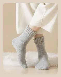 Detail view of thick grey knitted wool winter socks featuring a cozy looped texture.