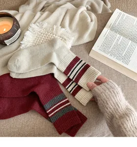Close-up detail of cozy wool winter socks with vintage striped cuffs in warm lifestyle setting.