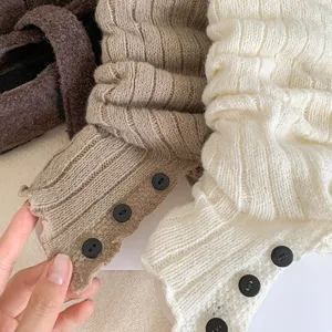 Knit leg warmers detail featuring textured ribbed fabric and decorative black buttons.