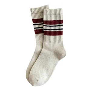 Cozy beige women crew socks featuring stylish red and black striped cuffs for autumn and winter wear.