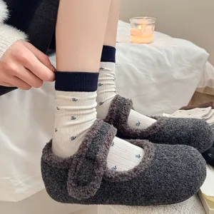 Cozy winter fuzzy house shoes and floral print mid-tube socks detail view for indoor warmth.