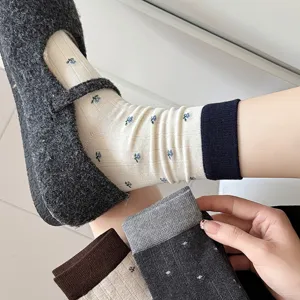 Detail shot of cozy women mid-calf socks featuring cute floral prints and contrast cuffs.