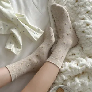 Detail shot of cozy floral knit socks in beige with cute flower pattern, soft fabric.